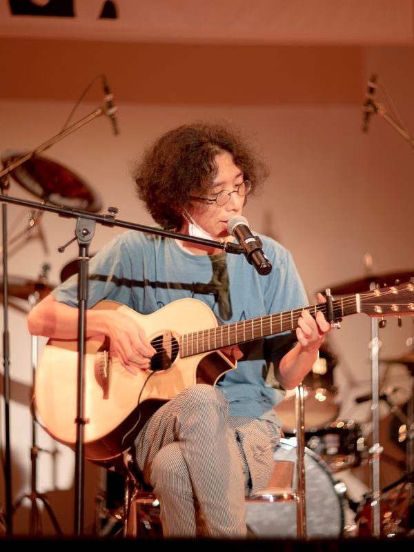 発表会でアコースティックギターを弾きながら歌う生徒さん